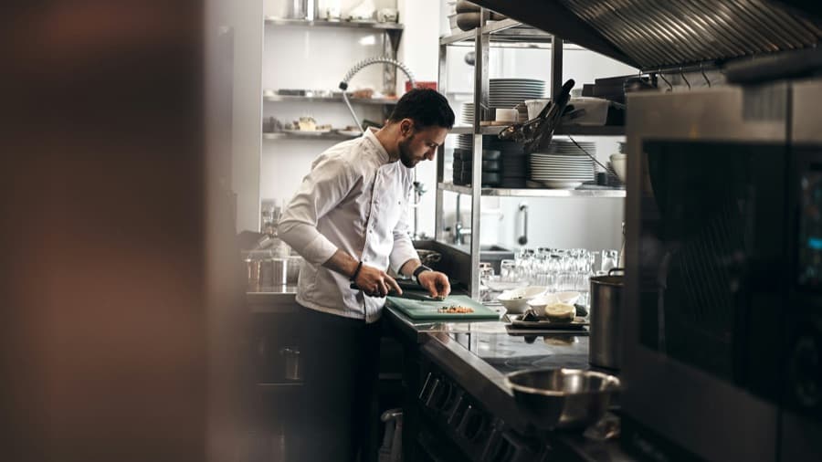 Cocinero prepara ingredientes en una cocina profesional